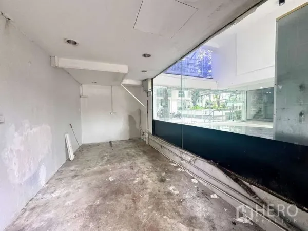 零售空间 出租在Bang Rak, Bangkok - 店内后勤与储物区，水泥地面及玻璃隔断。