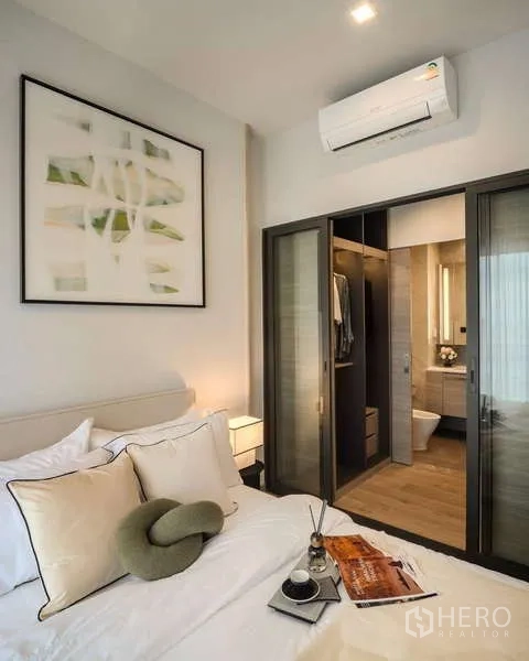 公寓 出租在Chatuchak, Bangkok - 卧室角度可见推拉门衣柜与浴室，墙面装饰画与空调。