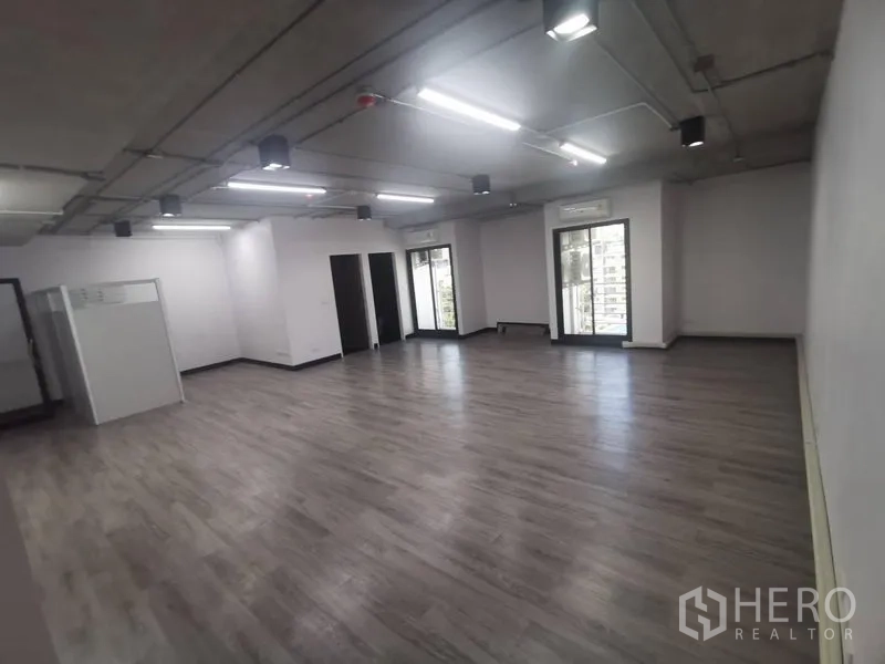 สำนักงาน ให้เช่า - ภาพมุมกว้างของพื้นที่ทำงานเปิดโล่ง พร้อมประตูกระจกมองออกสู่ทิวทัศน์ภายนอก