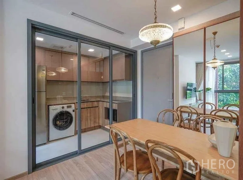 公寓 出租在Watthana, Bangkok - 封闭式厨房，推拉玻璃门，配洗衣机与充足柜体，邻餐区。