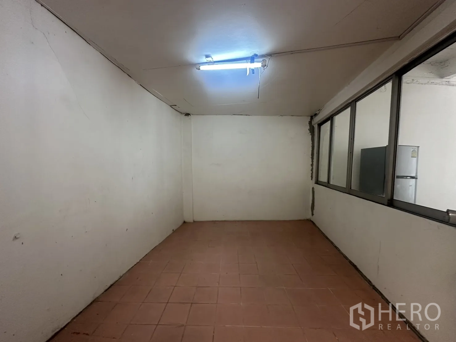 โฮมออฟฟิศ for rent in Watthana, Bangkok - ห้องปิดพื้นกระเบื้องพร้อมช่องหน้าต่างยาวข้างผนังกั้น.