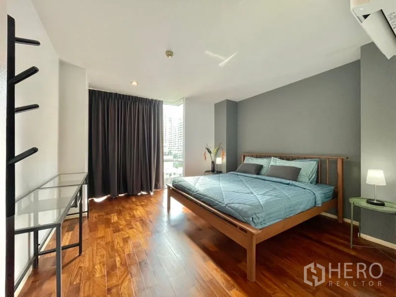 Condominium for rent or sale in Khlong Toei, Bangkok - Master bedroom with city view window, blackout curtains, and ample floor space.