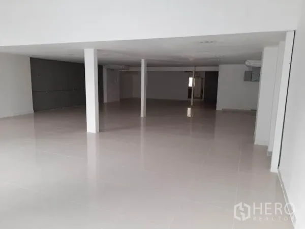 零售空间 出租在Ratchathewi, Bangkok - 开间式零售室内，亮面瓷砖地、白色立柱与嵌入式照明。
