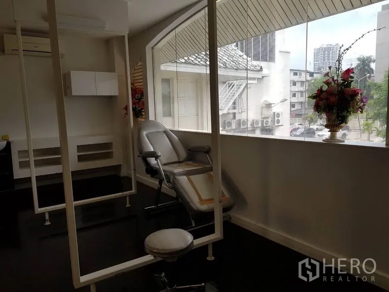 Retail Space for rent in Khlong Toei, Bangkok - Treatment room with reclining chair beside an expansive arched window and city outlook.