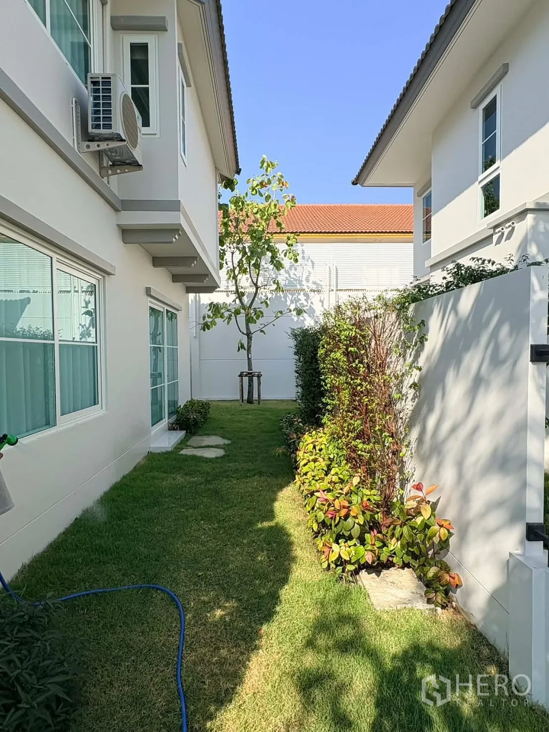 บ้าน for rent in Bang Phli, Samut Prakan - สนามหญ้าข้างบ้านระหว่างตัวบ้านสองฝั่ง พร้อมแปลงไม้พุ่มและต้นไม้เล็ก