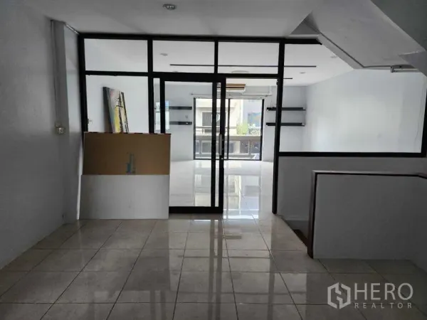 店屋 出租在Khlong Toei, Bangkok - 办公室区域，黑框玻璃隔断，连接明亮的瓷砖房间。