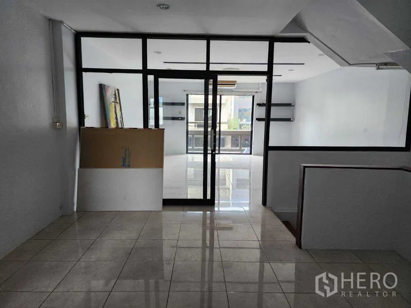 店屋 出租在Khlong Toei, Bangkok - 办公室区域，黑框玻璃隔断，连接明亮的瓷砖房间。