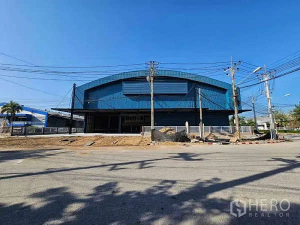 工厂 出租在Chon Buri - 大跨度拱形屋顶仓库正立面，设通风百叶，临路