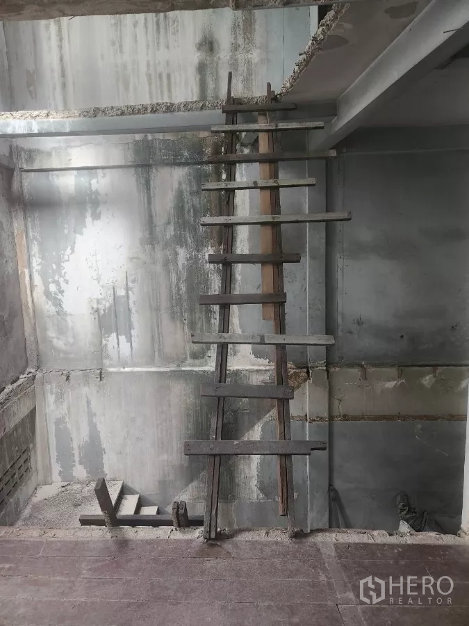 Shophouse for rent in Watthana, Bangkok - View across a central void to a temporary ladder and exposed concrete walls.
