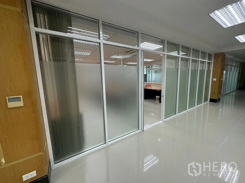 Office Space for rent in Suan Luang, Bangkok - Corridor with frosted glass partitioned offices, polished tile floor and bright ceiling lights in a Suan Luang, Bangkok office.