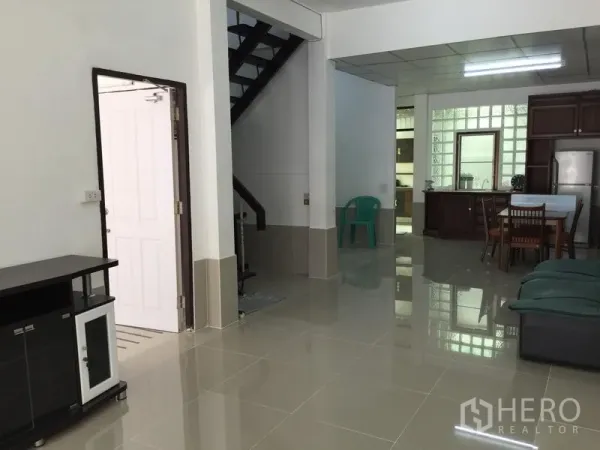 联排别墅 出租在Phra Khanong, Bangkok - 开放式客餐厅，亮面地砖，楼梯通往二层。