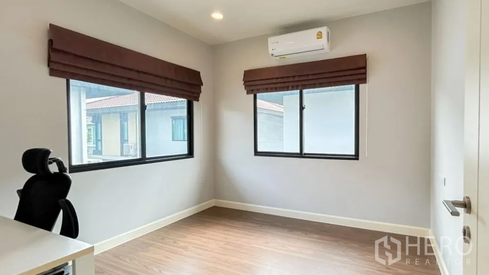 Detached House for sale in Lam Luk Ka, Pathum Thani - Second bedroom or home office with two windows and air-conditioning.