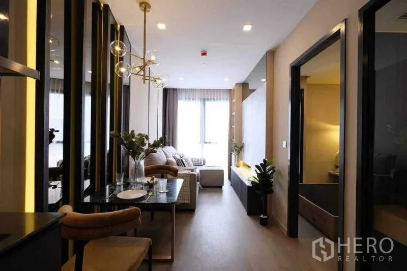 公寓 出租在Watthana, Bangkok - 开放式客餐厅，暖色灯光连向采光充足的窗户