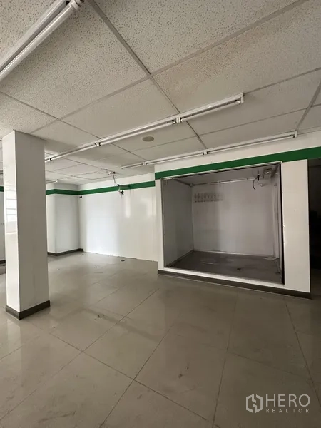 Retail Space for rent in Khlong Toei, Bangkok - Bright tiled open-plan space with grid ceiling lights and a recessed display bay.