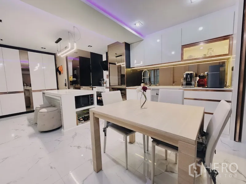 Condominium for sale in Bang Rak, Bangkok - Open-plan kitchen and dining with glossy white cabinets, island, and modern appliances.