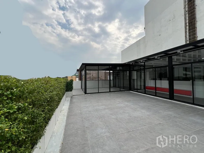 Retail Space for rent in Watthana, Bangkok - Expansive outdoor terrace with hedge screening beside a glass retail unit.