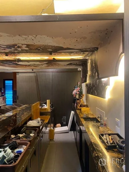 Shophouse for rent - Narrow bar service lane with backlit counters, storage, and ambient lighting.