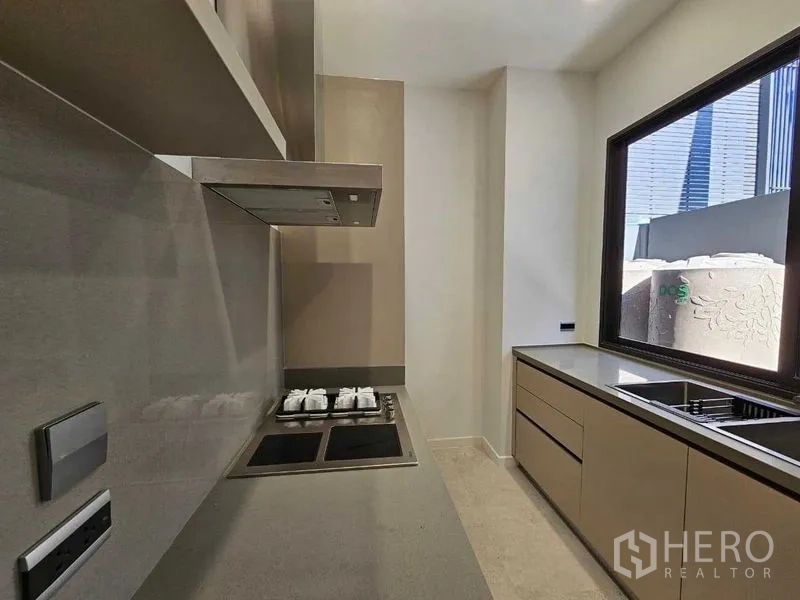 Detached House for rent in Wang Thonglang, Bangkok - Secondary kitchen with gas hob, hood, and ample cabinetry.