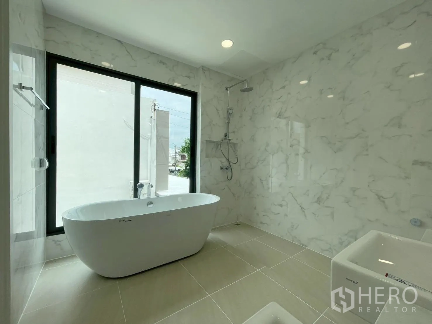 บ้านเดี่ยว for sale in Chatuchak, Bangkok - ห้องน้ำสว่างมีหน้าต่างบานใหญ่ อ่างอาบน้ำทรงรี และฝักบัวติดผนัง
