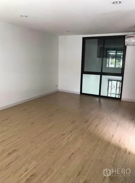 联排别墅 出租在Wang Thonglang, Bangkok - 楼上房间，木纹地板，黑框窗与空调。