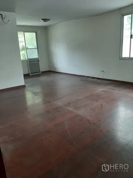 Retail Space for rent in Watthana, Bangkok - Empty upper-floor room with wooden flooring and two windows, ready for tenant fit-out.