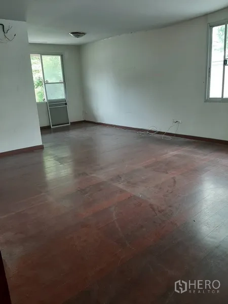 Retail Space for rent in Watthana, Bangkok - Empty upper-floor room with wooden flooring and two windows, ready for tenant fit-out.