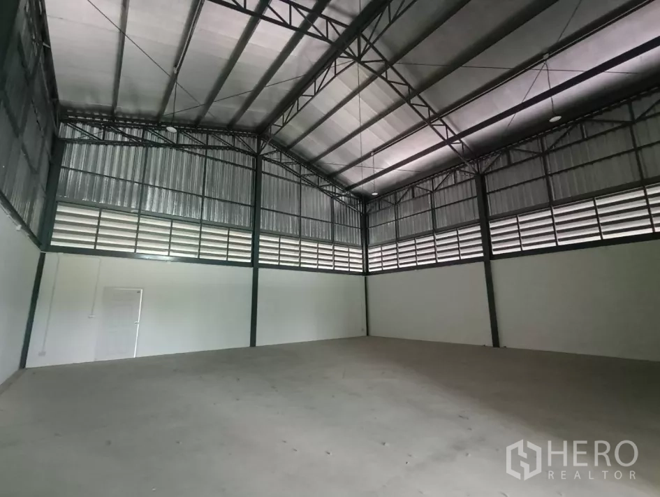 Factory for rent or sale in Bang Yai, Nonthaburi - Spacious warehouse interior with an 8-meter high steel roof and concrete flooring.