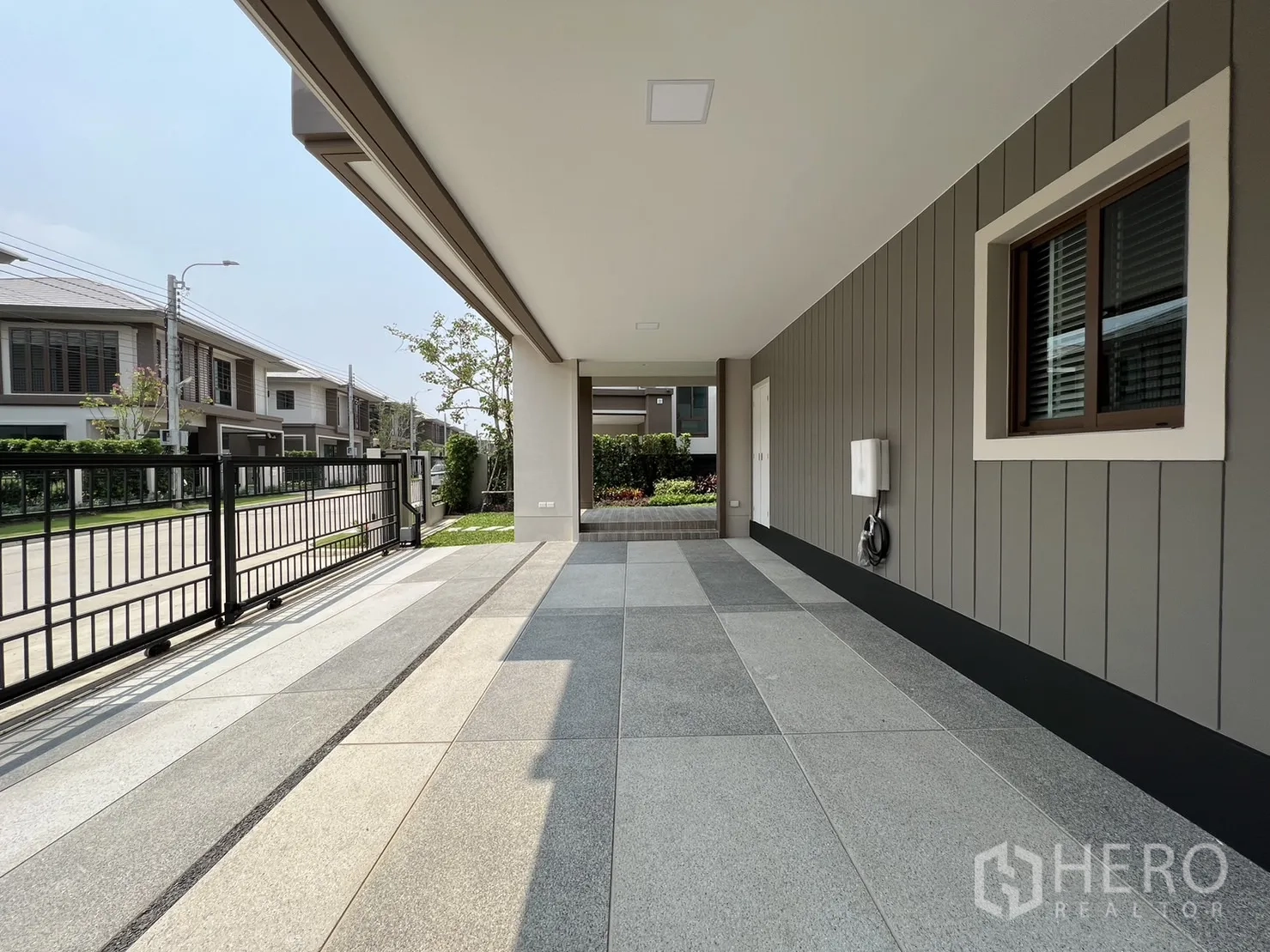 Detached House for rent in Bang Kapi, Bangkok - Spacious shaded parking area with tiled floor facing a quiet street.