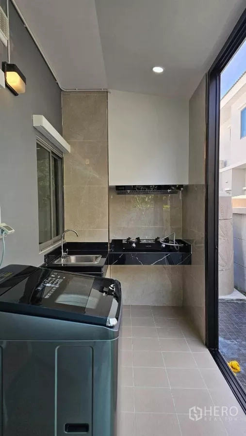Detached House for rent in Bang Phli, Samut Prakan - Enclosed Thai kitchen and laundry with gas hobs, sink and washing machine.
