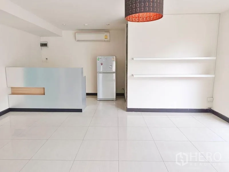 Retail Space for rent - Open retail area with pendant light, wall shelving, air-conditioning and refrigerator.