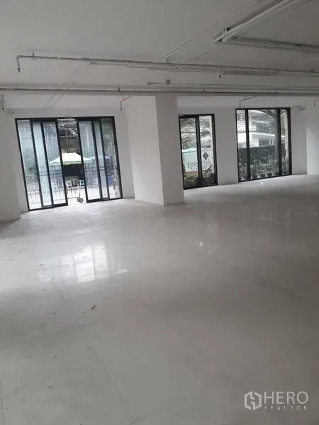Retail Space for rent in Watthana, Bangkok - Spacious shop floor with multiple floor-to-ceiling sliding glass doors and natural light.