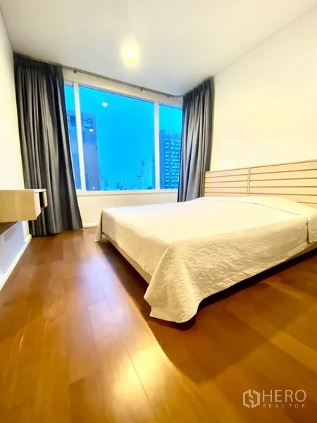 公寓 出租在Watthana, Bangkok - 卧室配双人床、木地板与大窗城市景观
