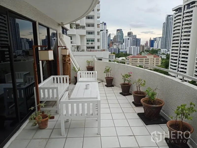 公寓 出租或出售在Watthana, Bangkok - 大露台，城市景观，白色户外家具与盆栽。