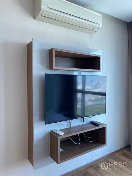 公寓 出售在Ratchathewi, Bangkok - 壁挂电视柜与置物格，分体空调在上方可见。