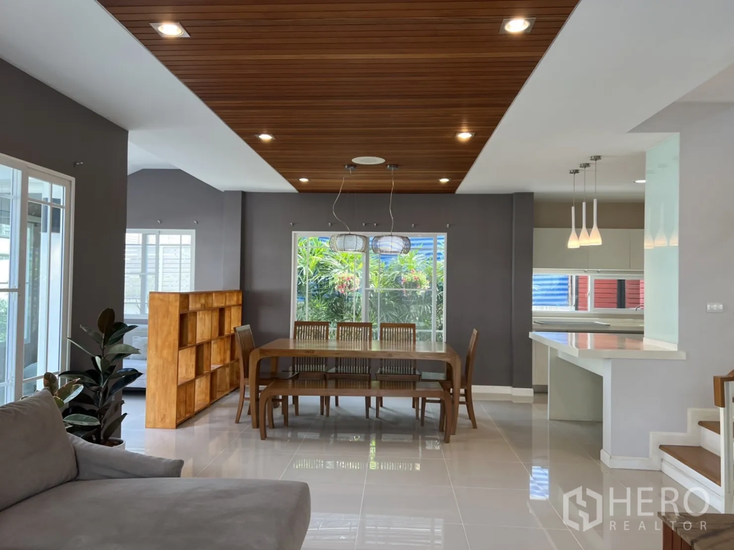 Detached House for rent in Bang Kapi, Bangkok - Open‑plan dining area with wooden ceiling, dining set, pendant lights, and a breakfast counter.
