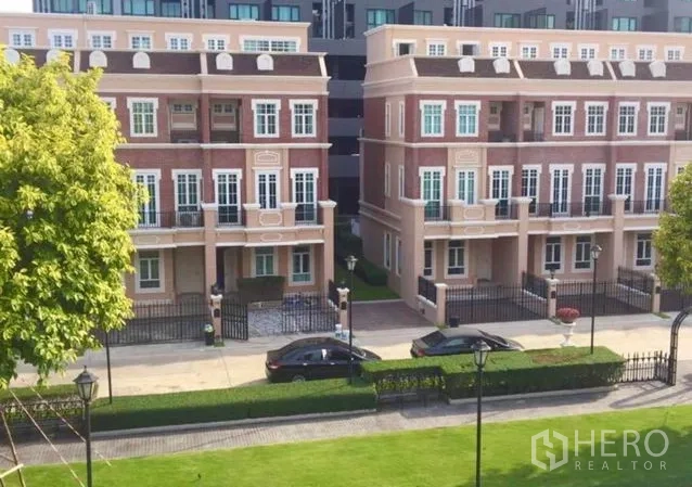 Townhouse for rent or sale in Bangkok - View of landscaped townhouse community with twin rows of homes and green lawn.