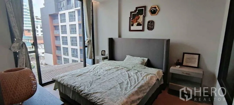 公寓 出租在Watthana, Bangkok - 转角卧室，落地窗眺望社区城市景观。