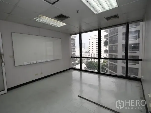 办公空间 出租在Watthana, Bangkok - 转角办公室，落地窗城市景观、白板与网格吊顶灯。