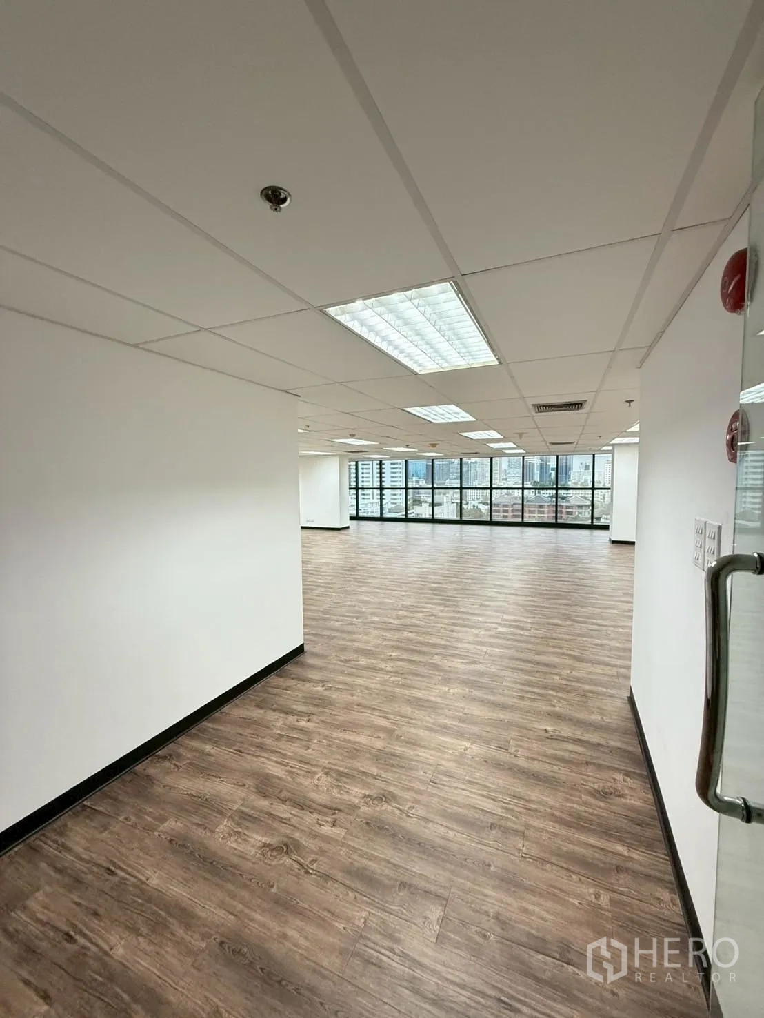 Office Space for rent in Watthana, Bangkok - Entrance hallway with glass door leading into a bright workspace with large windows.