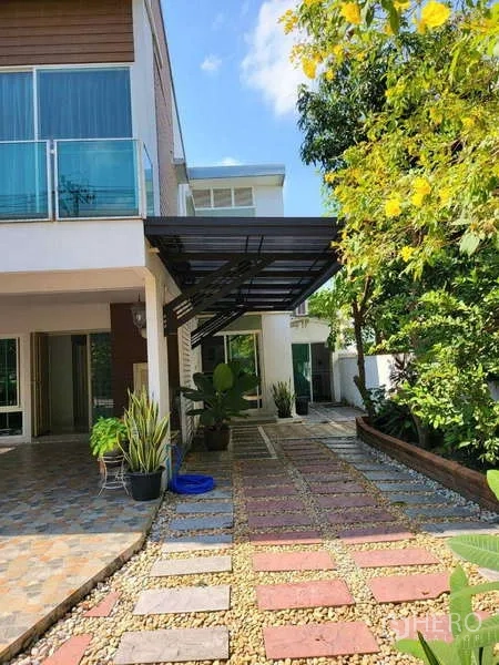 独立式住宅 出租在Lat Krabang, Bangkok - 房屋侧院步道，铺踏石与卵石，旁有带顶车棚。