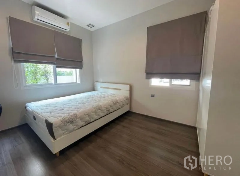 Detached House for rent in Lat Krabang, Bangkok - Cozy bedroom with bed, air conditioner, two windows and wood flooring