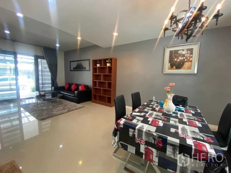 Home Office for rent or sale in Bang Phli, Samut Prakan - Open-plan living and dining area with chandelier, gray walls and bookshelf.