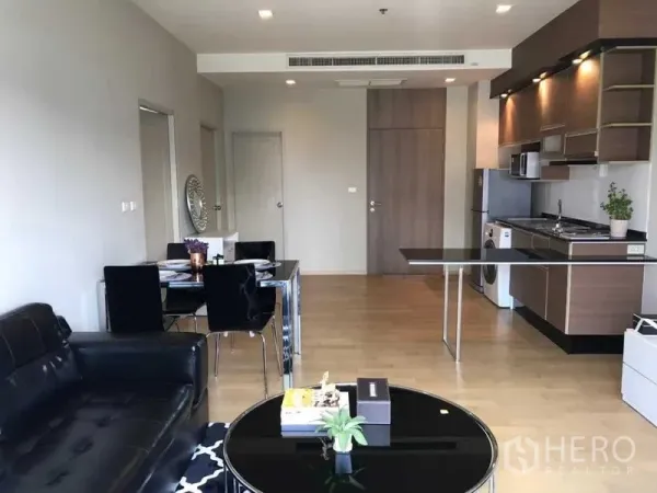 公寓 出租在Watthana, Bangkok - 开放式客厅与现代厨房，木质橱柜、内置电器及洗衣机