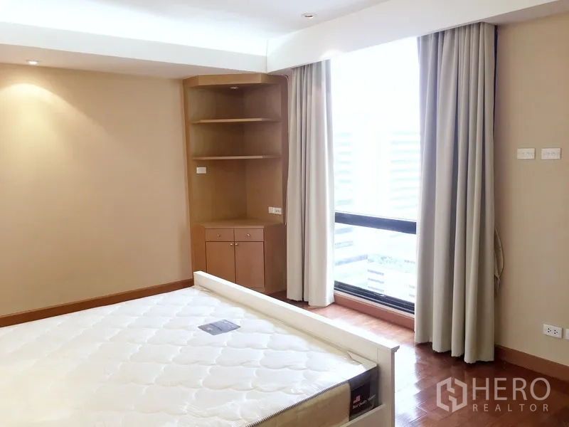 公寓 出租在Pathum Wan, Bangkok - 卧室转角带内置层架，大窗配窗帘。