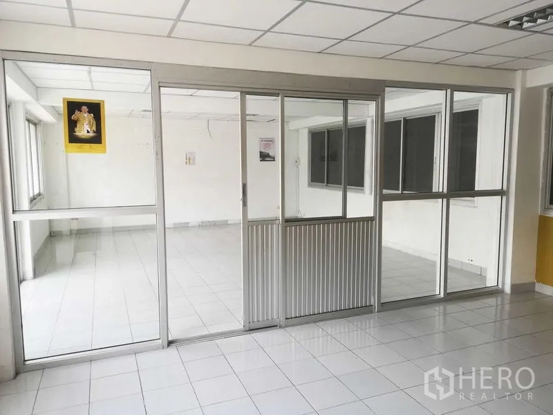 Factory for sale in Khlong Luang, Pathum Thani - Sliding glass partitions separating two office rooms inside the factory.