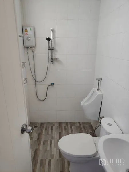 Factory for sale in Sai Noi, Nonthaburi - Clean bathroom with shower, toilet and urinal inside the factory.