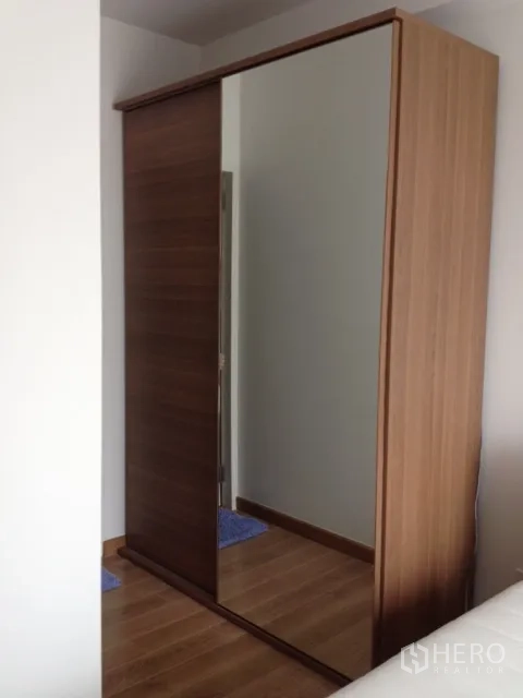 公寓 出租在Khlong Toei, Bangkok - 卧室内木质推拉门衣柜，带全身镜。