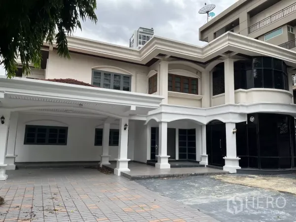 Detached House for rent in Watthana, Bangkok - Two-storey detached house in Watthana with white arches, black-framed windows and a covered carport.