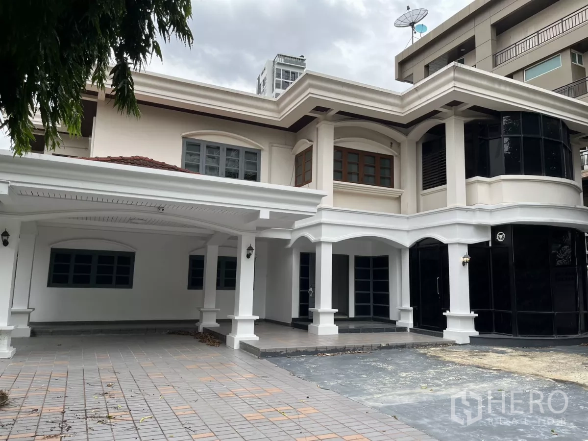 Detached House for rent in Watthana, Bangkok - Two-storey detached house in Watthana with white arches, black-framed windows and a covered carport.