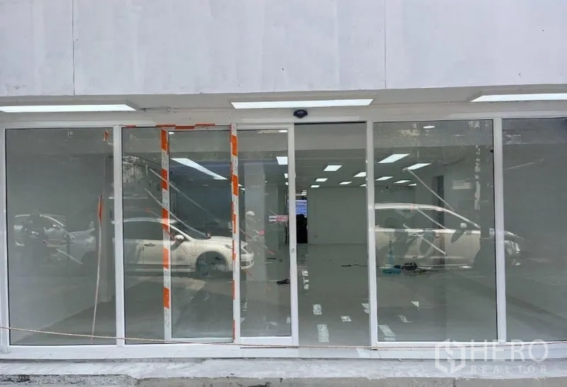 Retail Space for rent in Khlong Toei, Bangkok - Wide glass storefront with sliding doors and LED canopy lighting.